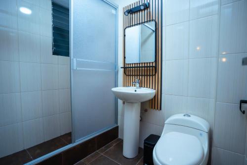 a bathroom with a sink and a toilet and a mirror at Samaran Wuasi in Puno