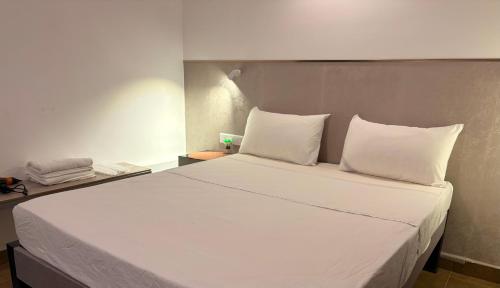 a bed with white sheets and pillows in a room at Ace Lagoon View Airport Hotel in Katunayaka