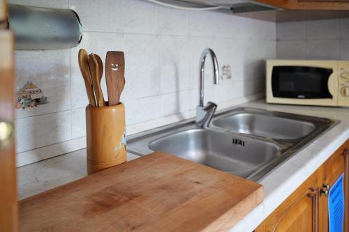 a kitchen counter with a sink and a knife block at B&BTorre Cives in Vidracco