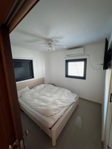a bedroom with a white bed and a window at Boutique in Rothschild in Rishon LeẔiyyon