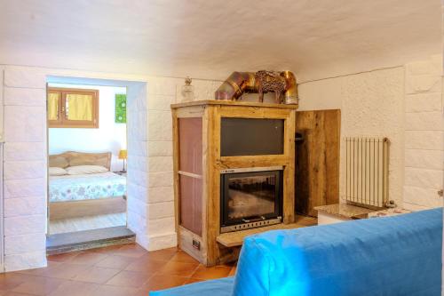 a living room with a fireplace and a tv at B&BTorre Cives in Vidracco