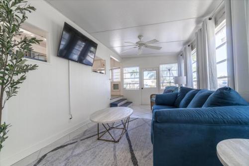 a living room with a blue couch and a tv at Cozy Conch Cottage in Cudjoe Key