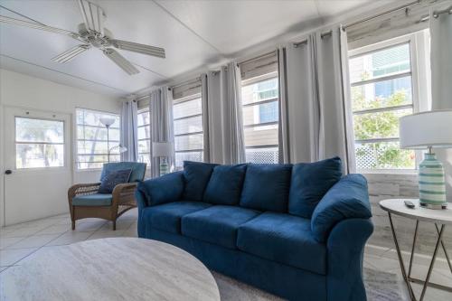 a blue couch in a living room with windows at Cozy Conch Cottage in Cudjoe Key