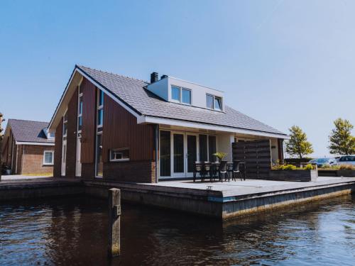 a house on a dock next to a body of water at Holiday Home Dorregeest-1 by Interhome in Uitgeest