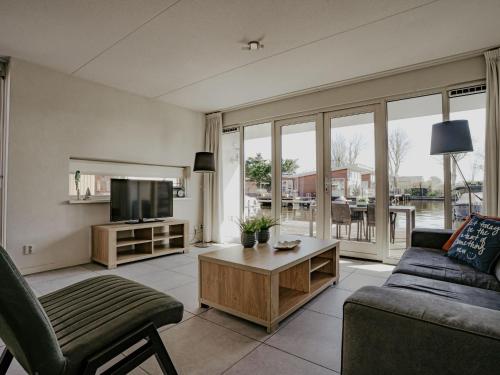 a living room with a couch and a tv at Holiday Home Dorregeest-1 by Interhome in Uitgeest