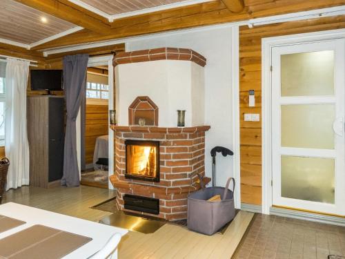 a living room with a brick fireplace in a house at Holiday Home Renkitupa by Interhome in Saarenkylä