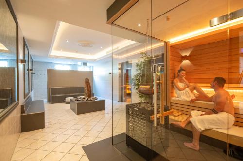 a man and a woman sitting in a sauna at Schloß-Hotel Petry in Treis-Karden