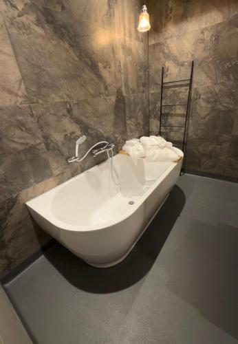 a white bath tub sitting in a bathroom at Eighty One Horse Boulevard in Valkenswaard