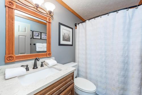 a bathroom with a sink and a toilet and a mirror at Crows Nest by Railey Vacations in Swanton