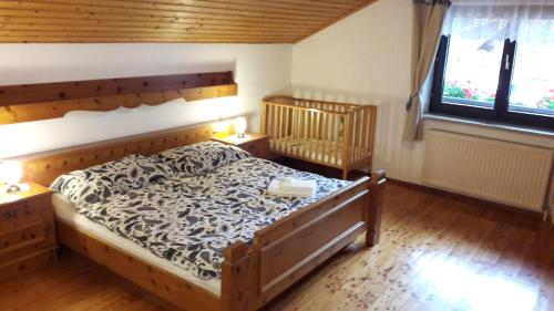 ein Schlafzimmer mit einem Bett in einem Zimmer mit Holzböden in der Unterkunft Ferienhof Halmersberg in Weyer Markt