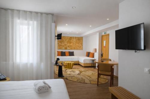 a hotel room with a bed and a couch at Hotel Zenite in Angra do Heroísmo