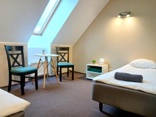 a bedroom with two beds and a table and chairs at Aiakeskuse hostel in Rakvere