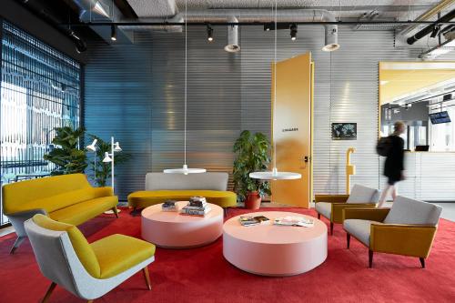 a lobby with chairs and tables and a person walking at The Social Hub Groningen Extended Stay in Groningen
