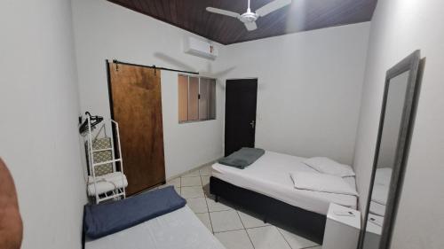 a small bedroom with a bed and a mirror at Morada dos Anjos in Aparecida