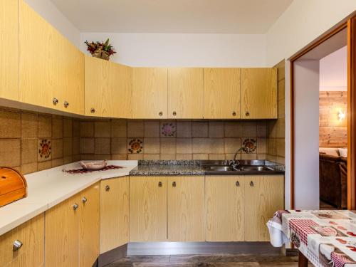 a kitchen with wooden cabinets and a sink at Apartment Cristina by Interhome in Campestrin