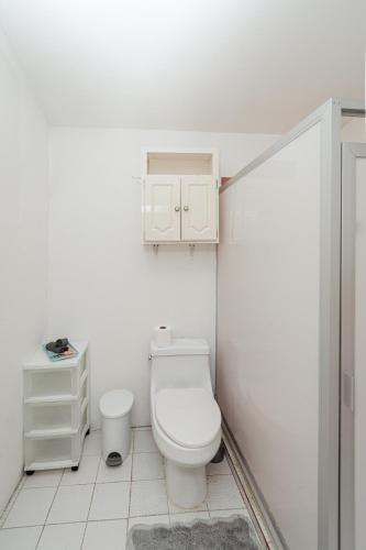 a white bathroom with a toilet and a sink at Departamento Palmerín in La Paz