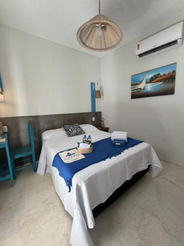 a bedroom with a bed with a blue blanket at Pousada Villa Santorini Preá in Cruz