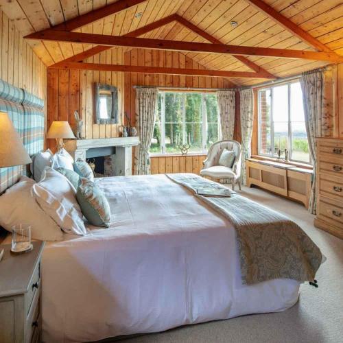 a large bedroom with a large bed and a window at The Shooting Lodge in Charminster