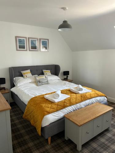 a bedroom with a large bed with towels on it at Hotdog House Filey Detached Pet Friendly Eco-House in Hunmanby