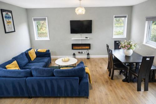 a living room with a blue couch and a table at Stunning Lodge with Hot Tub in Harrogate