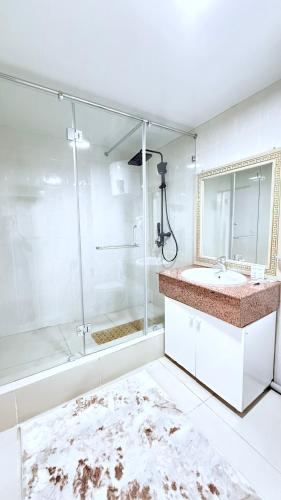 a bathroom with a shower and a sink and a mirror at Sultan Saray in Türkistan