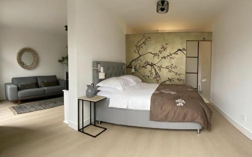 a bedroom with a large bed and a couch at The East Wing Bloemendaal in Bloemendaal
