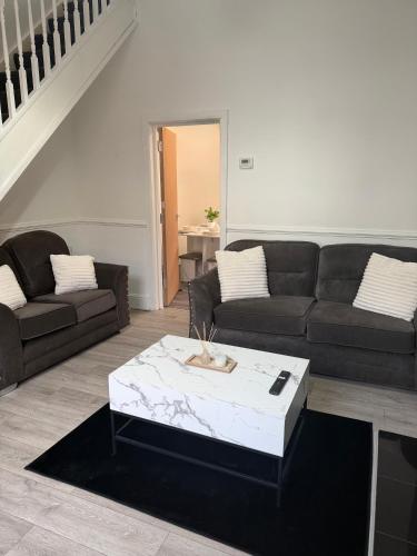 a living room with a couch and a coffee table at Deepdale House - Comfortable 2 Bedroom Home near Major Attractions in Preston in Preston