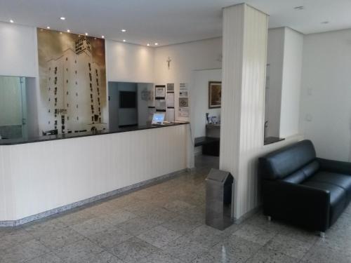 a waiting room with a black leather chair in a building at Hotel Globo Rio in Sao Jose do Rio Preto