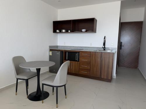 a kitchen with a table and two chairs and a counter at MIRAMARE Ocean View in Puerto Morelos
