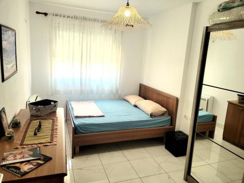 a small bedroom with a bed and a mirror at Appartament ZEA in Durrës