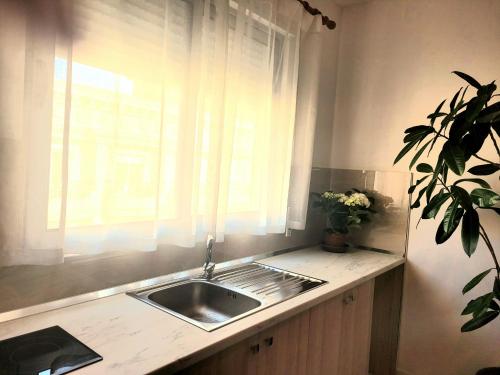 a kitchen counter with a sink and a window at Appartament ZEA in Durrës