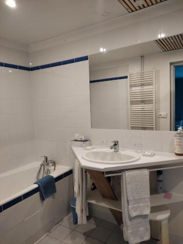 a white bathroom with a sink and a tub at Le Logis du Pradet in Moncrabeau