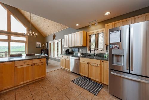 a large kitchen with wooden cabinets and stainless steel appliances at Chubby Bunny Lodge by Railey Vacations in McHenry