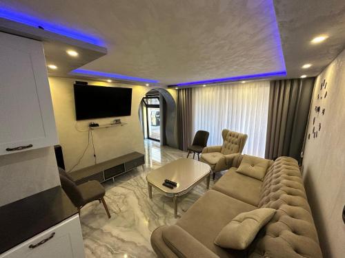 a living room with a couch and a tv at Apartments Dream in Sarnitsa