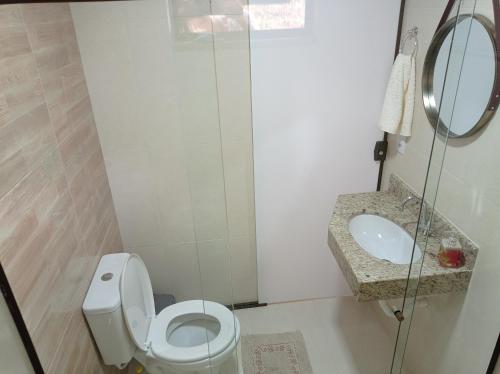 a small bathroom with a toilet and a sink at Chalés Pôr do Sol Alto Caparaó in Caparaó Velho