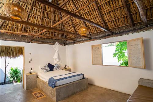 a bedroom with a bed in a room with a window at El Paredon Beach, Casa Yemanja in El Paredón Buena Vista