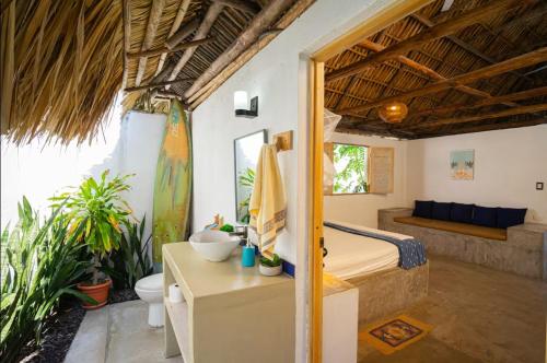 a bedroom with a bed and a bathroom at El Paredon Beach, Casa Yemanja in El Paredón Buena Vista