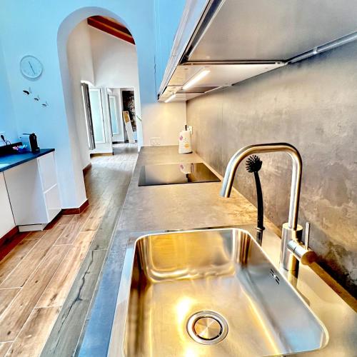 a kitchen with a stainless steel sink in a room at R&V Apartments - Nel cuore di La Spezia in La Spezia