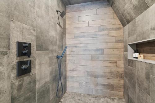 a shower stall in a bathroom with a stone wall at Lake Bomoseen - Lake Access, Fire Pit & BBQ in Castleton