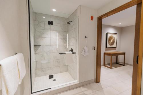 a bathroom with a shower with a glass door at Highpoint Hotel in Sioux Falls
