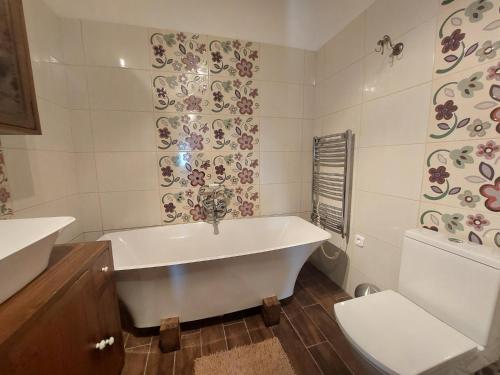 a white bathroom with a tub and a toilet at Siske malom in Balatonfüred
