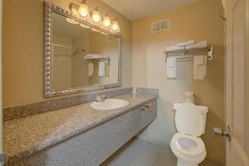 a bathroom with a sink and a toilet and a mirror at Capital O Duncanville Tx in Duncanville