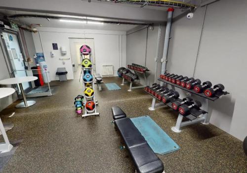 a gym with several rows of dumbbells and weights at iQ Parker House Dundee in Dundee