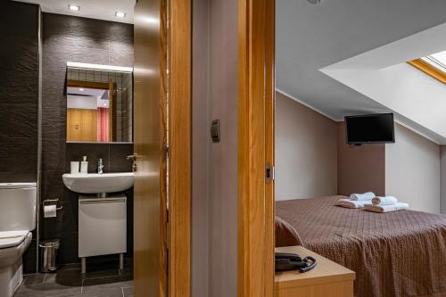 a bathroom with a bed and a sink in a room at Apartamentos Spa Cueto in Cangas de Onís