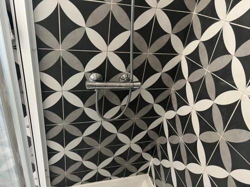 a bathroom with a black and white patterned wall at Al Amoreirinha Rui Barata in Castelo Branco