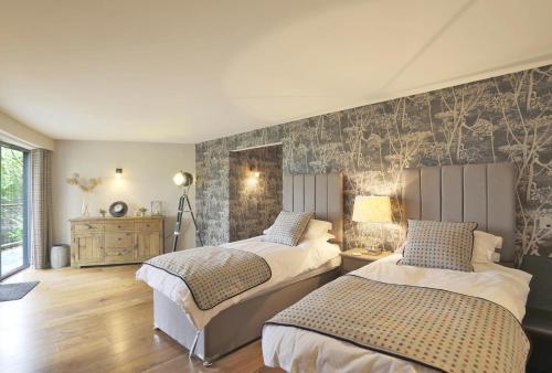 a bedroom with two beds and a wall at 6 Bed in Lavenham oc-stofa in Lavenham