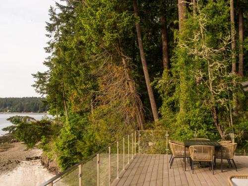 a table and chairs on a walkway next to a beach at The Bald Seagle in Port Orchard
