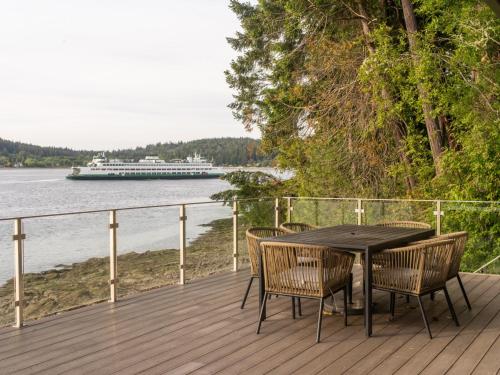 a table and chairs on a deck with a cruise ship at The Bald Seagle in Port Orchard