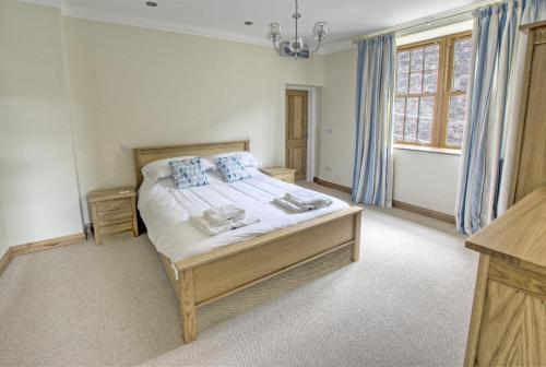a bedroom with a large bed with blue curtains at 1 Bed in Seaton oc-mbsov in Seaton