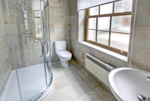 a bathroom with a shower and a toilet and a sink at 1 Bed in Seaton oc-mbsov in Seaton